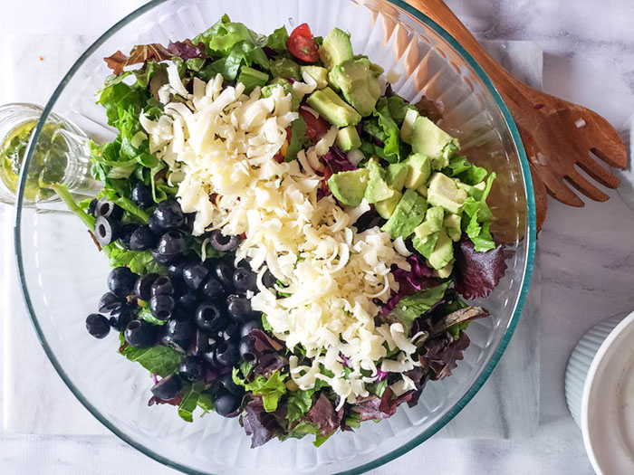 overhead view of salad with cheese and olives on top