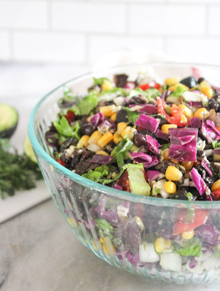 a close up of Mexican chopped salad in a glass bowl