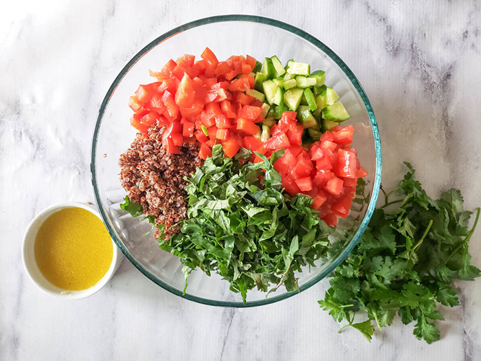 Quinoa salad ingredients in a bowl not mixed