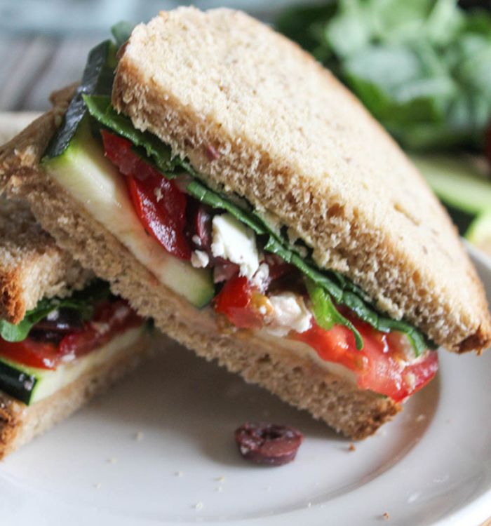 a half of vegetable mediterranean sandwich on a plate