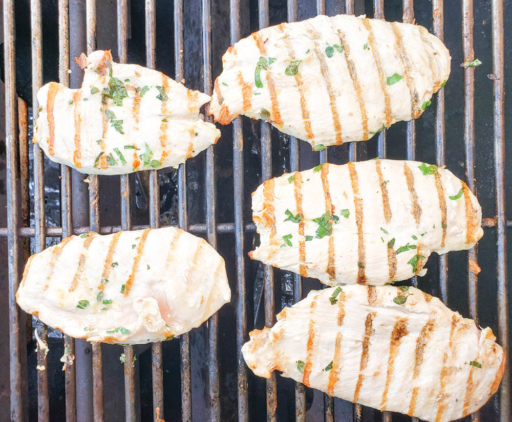 chicken cutlets cooking on grill