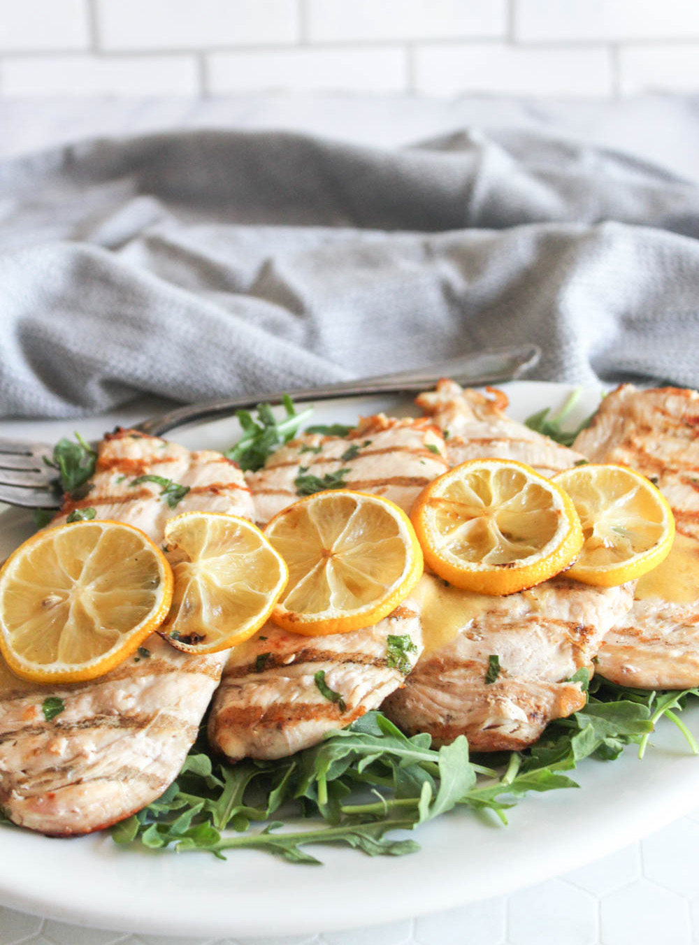 chicken piallard on a platter with lemon slices on top