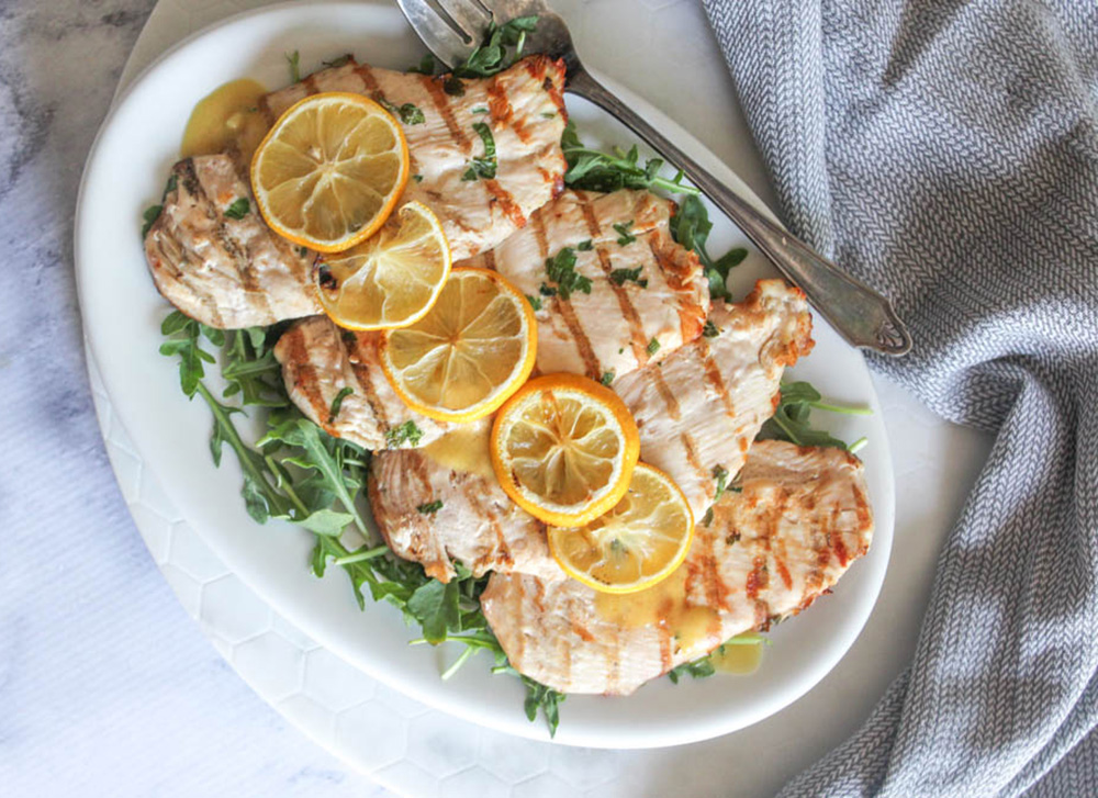 overhead view of chicken piallard on a plate with lemon