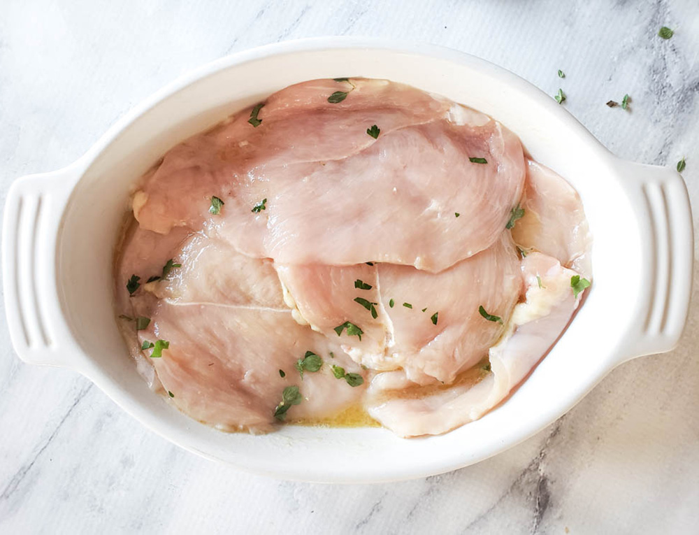 chicken piallard marinating in a shallow bowl