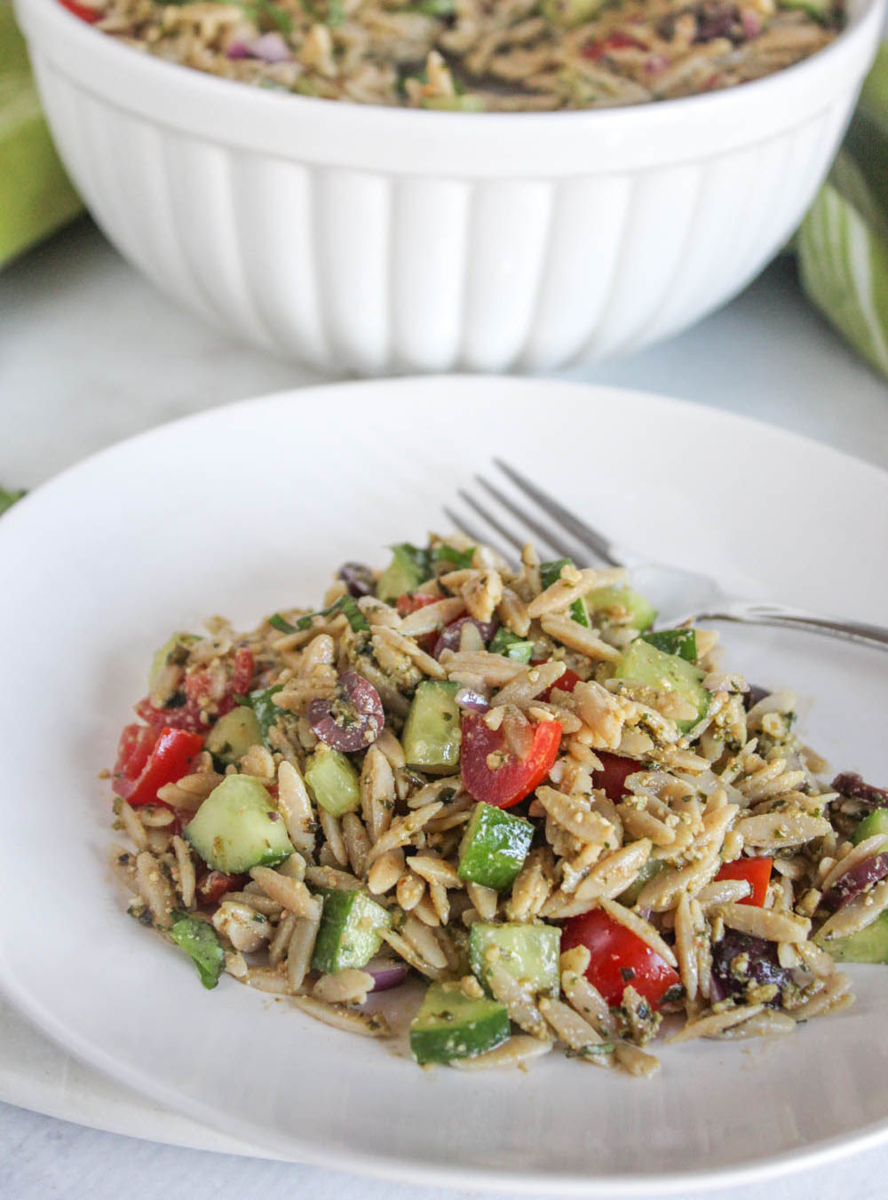 pesto orzo on a plate with a fork