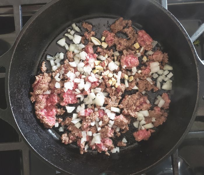 ground beef and onions cooking in a skillet