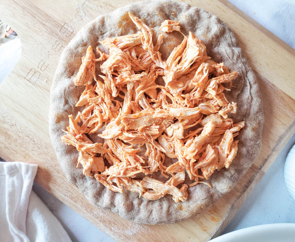 shredded buffalo chicken on a flatbread not cooked