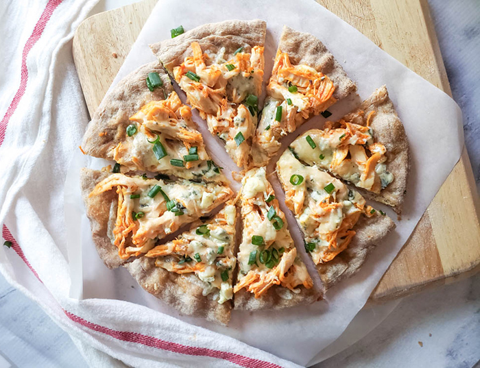 overhead view of buffalo chicken flatbread on a board