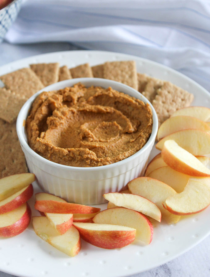 pumpkin pie hummus on a plate with apples and graham crackers