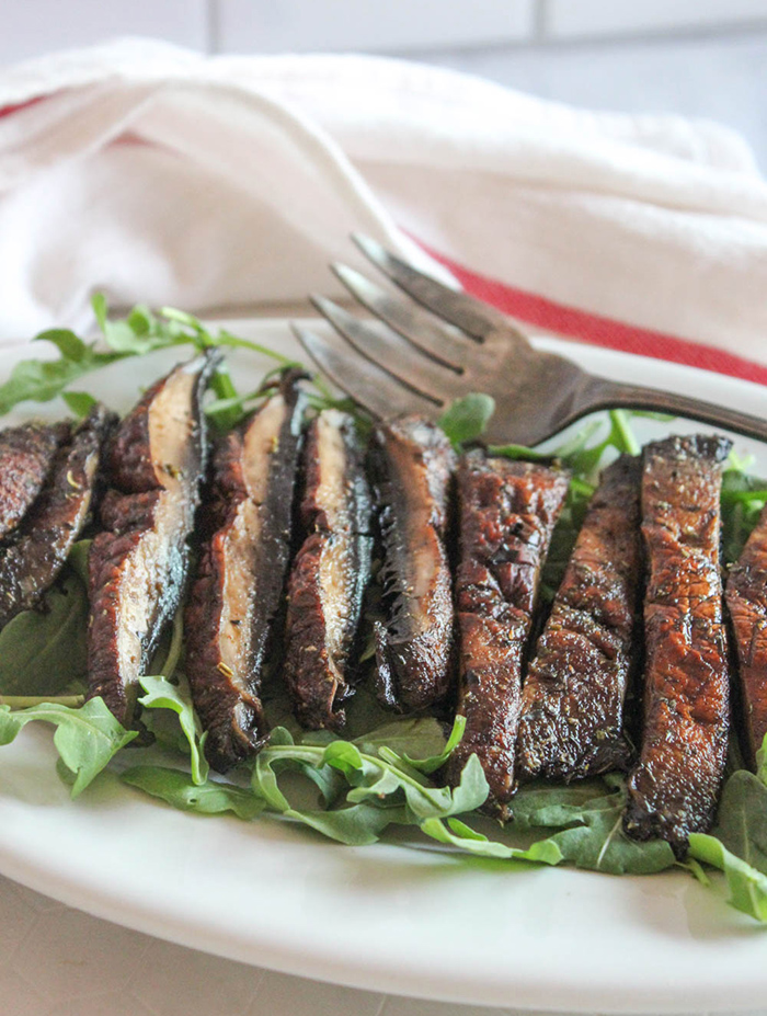 sliced air fried mushroom on a platter with a fork