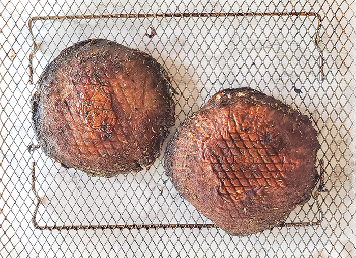 Last step of process cooked portobello mushrooms on an air fryer basket