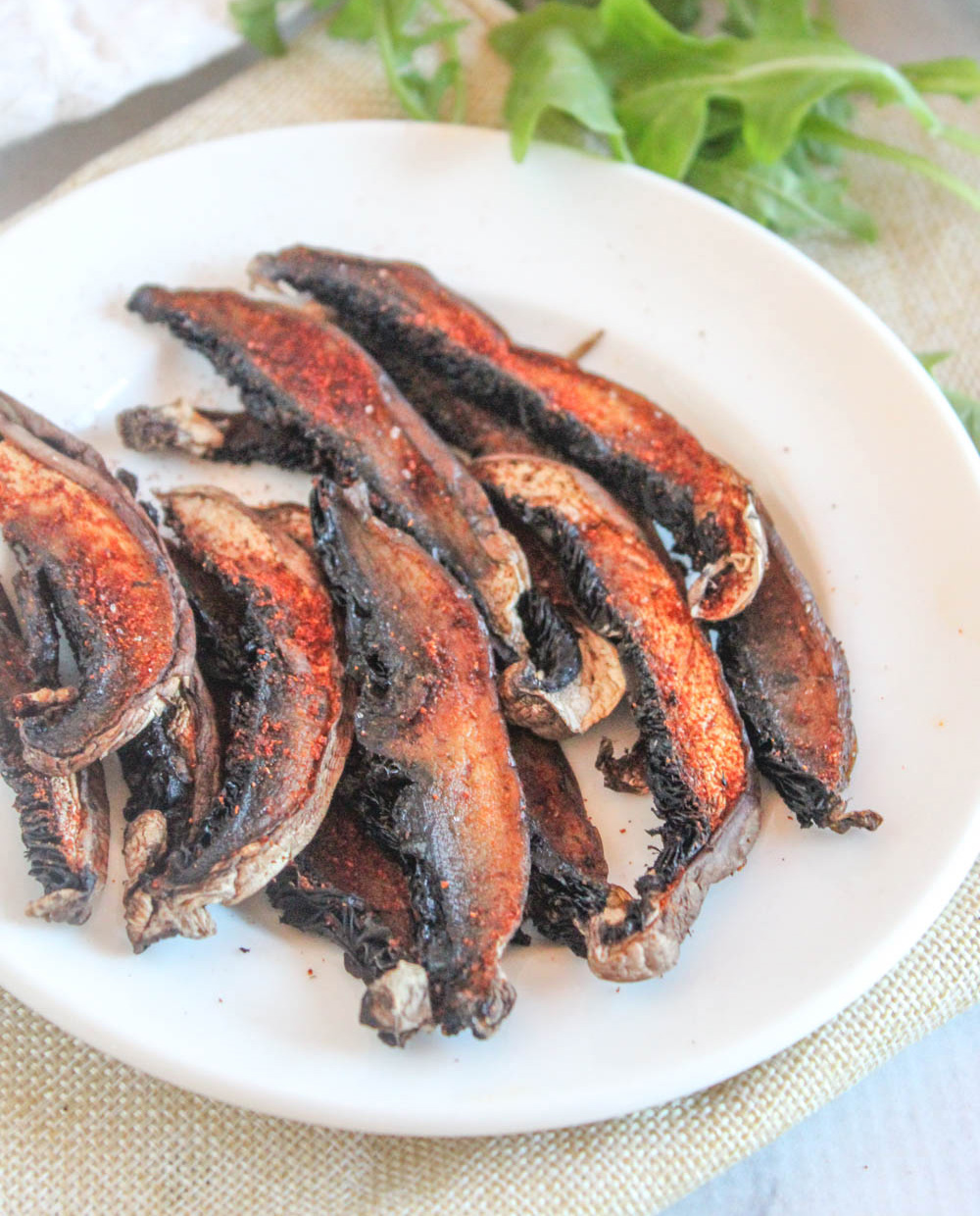 close up view of cooked mushroom bacon slices on a white plate