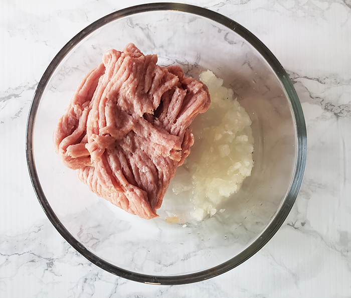 process shot of ground turkey and onions in a bowl