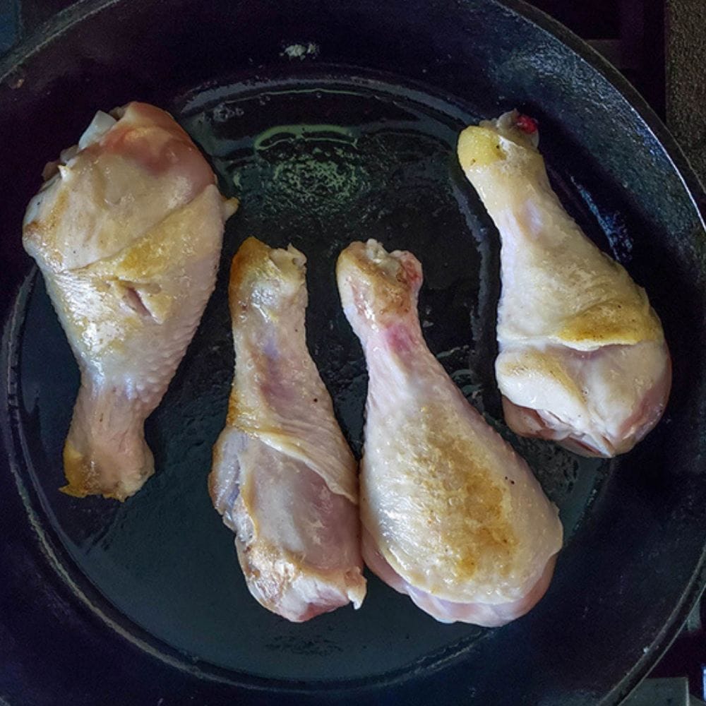 step one, chicken legs cooking in a skillet