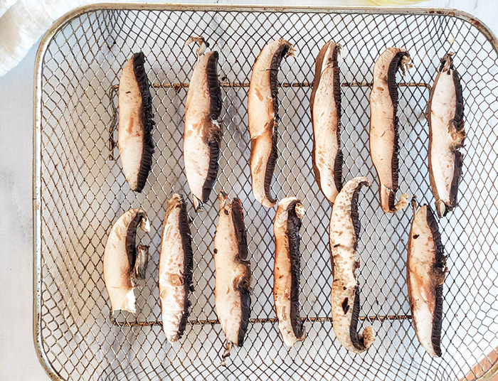 slices of plain mushrooms on an air fryer tray