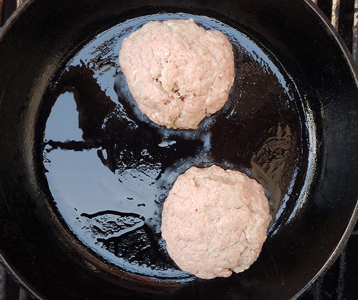 process shot of turkey burgers cooking in a pan