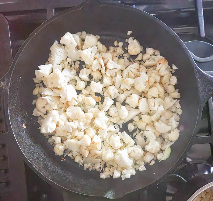 cauliflower pieces cooking on top of the stove