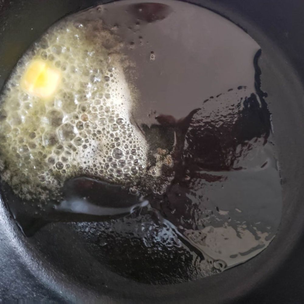 Butter melting in pan on stovetop over medium hear. Butter sauce contains garlic and lemon juice.