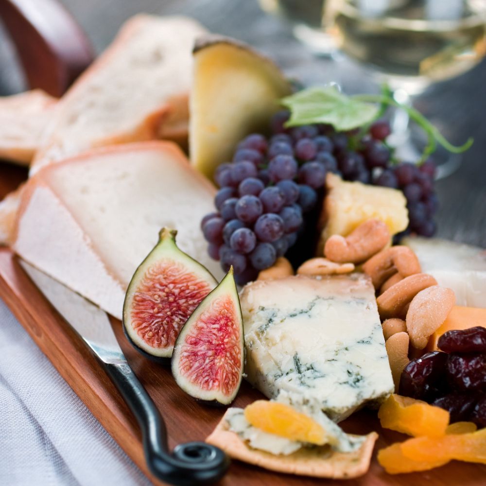 fresh figs on a cheese board with blue cheese grapes and crackers