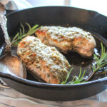 close up of two pieces of chicken savoy in a skillet with a spoon