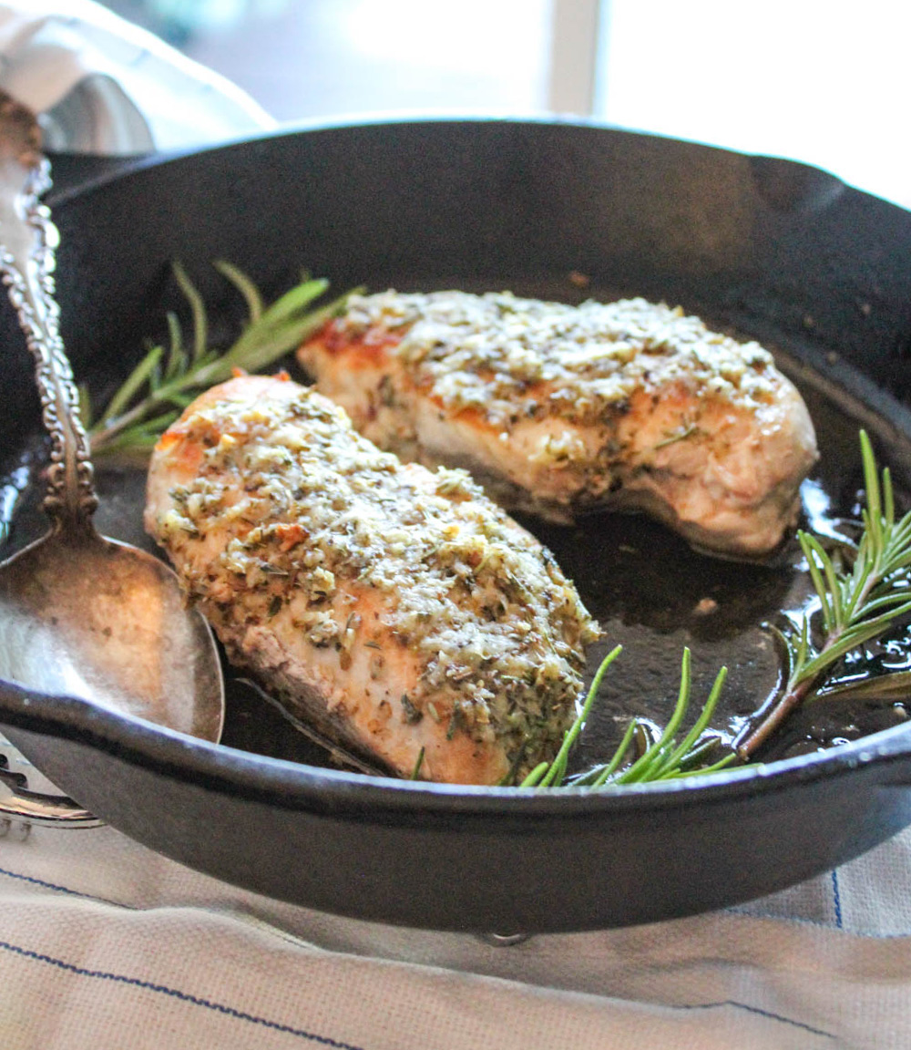 close up of two pieces of chicken savoy in a skillet with a spoon