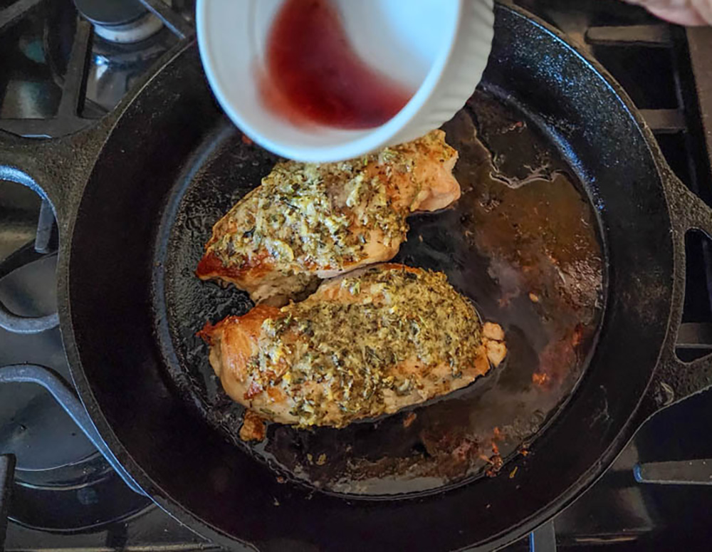 a picture of adding vinegar to chicken savoy