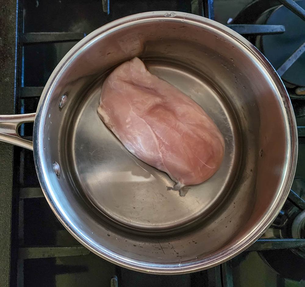 chicken in a pan with water not cooked