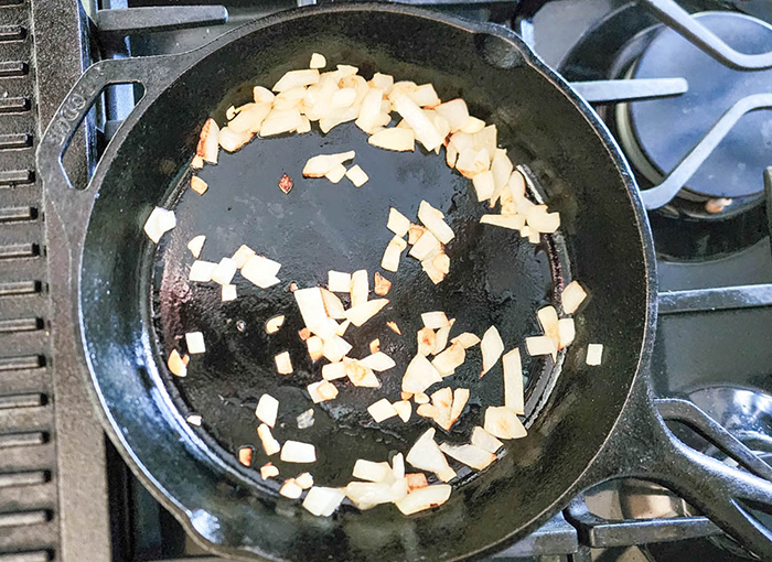 garlic and onions cooking in a skillet