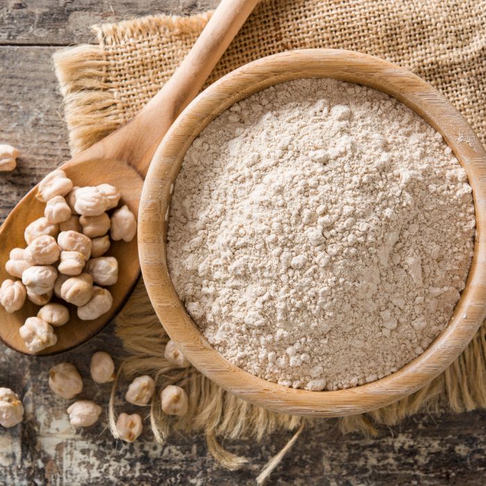 chickpea flour with a spoon of chickpeas next to it