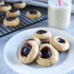 butter cookies with jam on a white plate with a milk bottle in the background