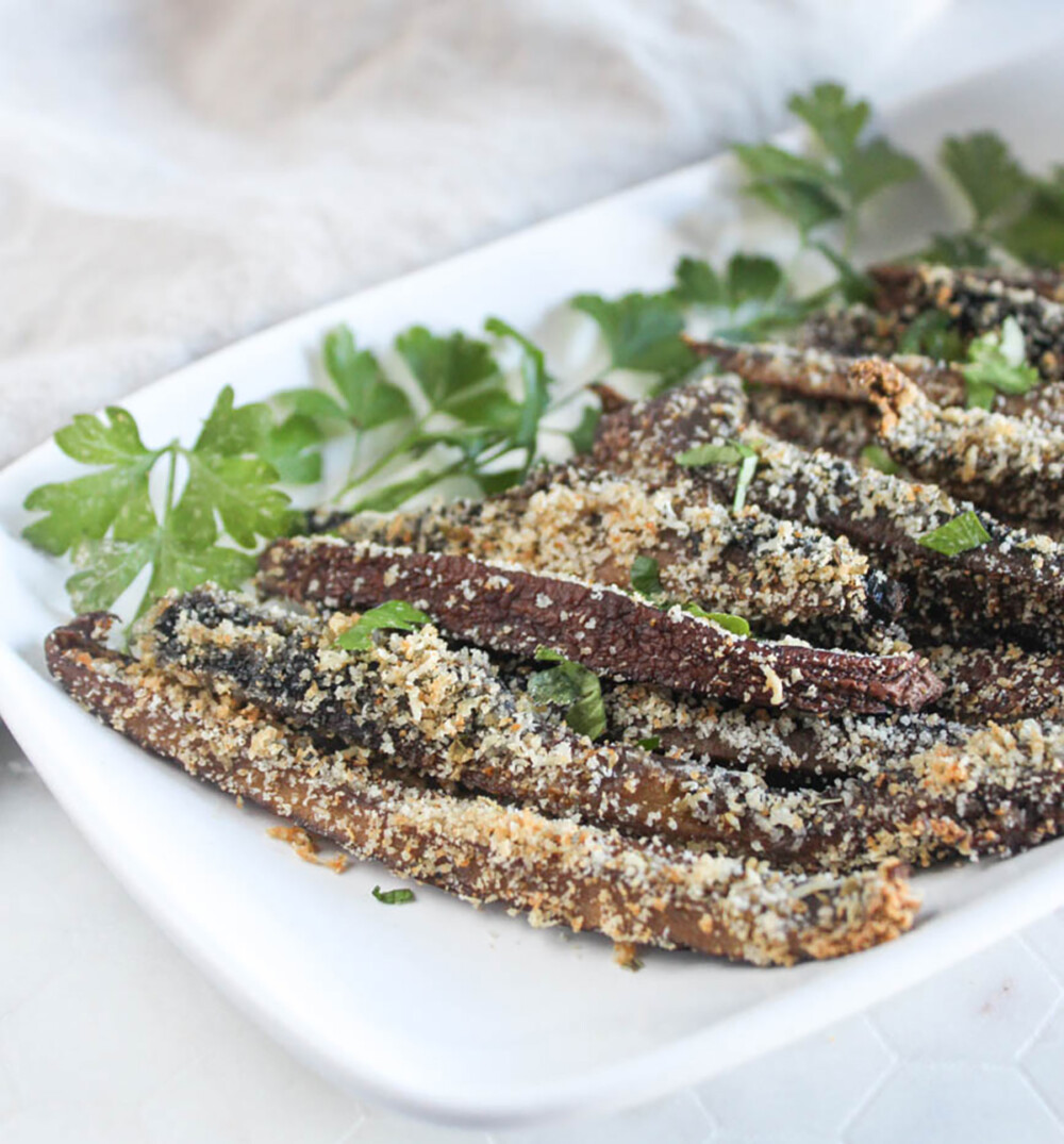 a close up picture of mushroom fries on a white tray