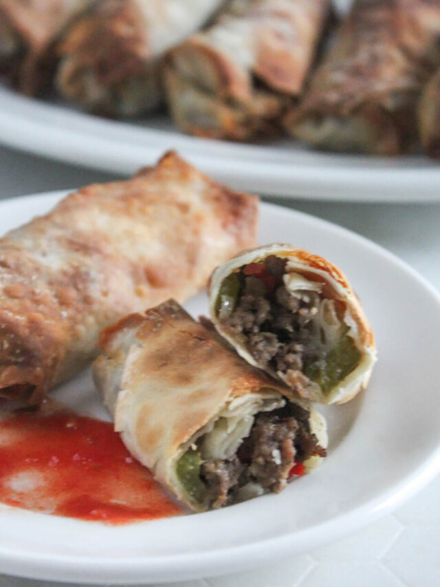 Egg roll cut in half with marinara sauce on a plate