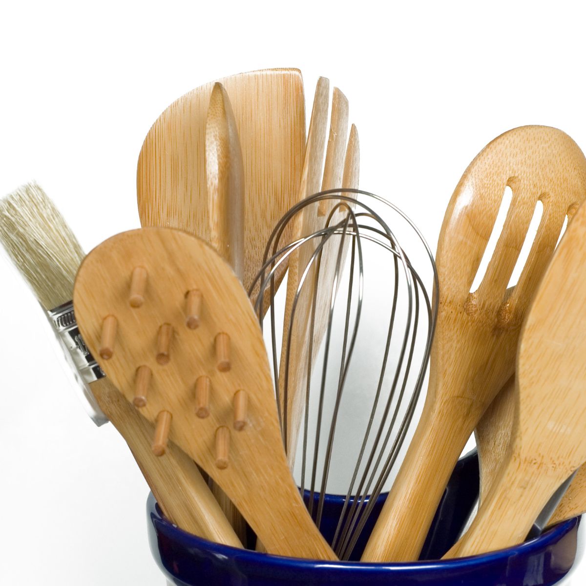 wooden spoons and whisks in a blue jar