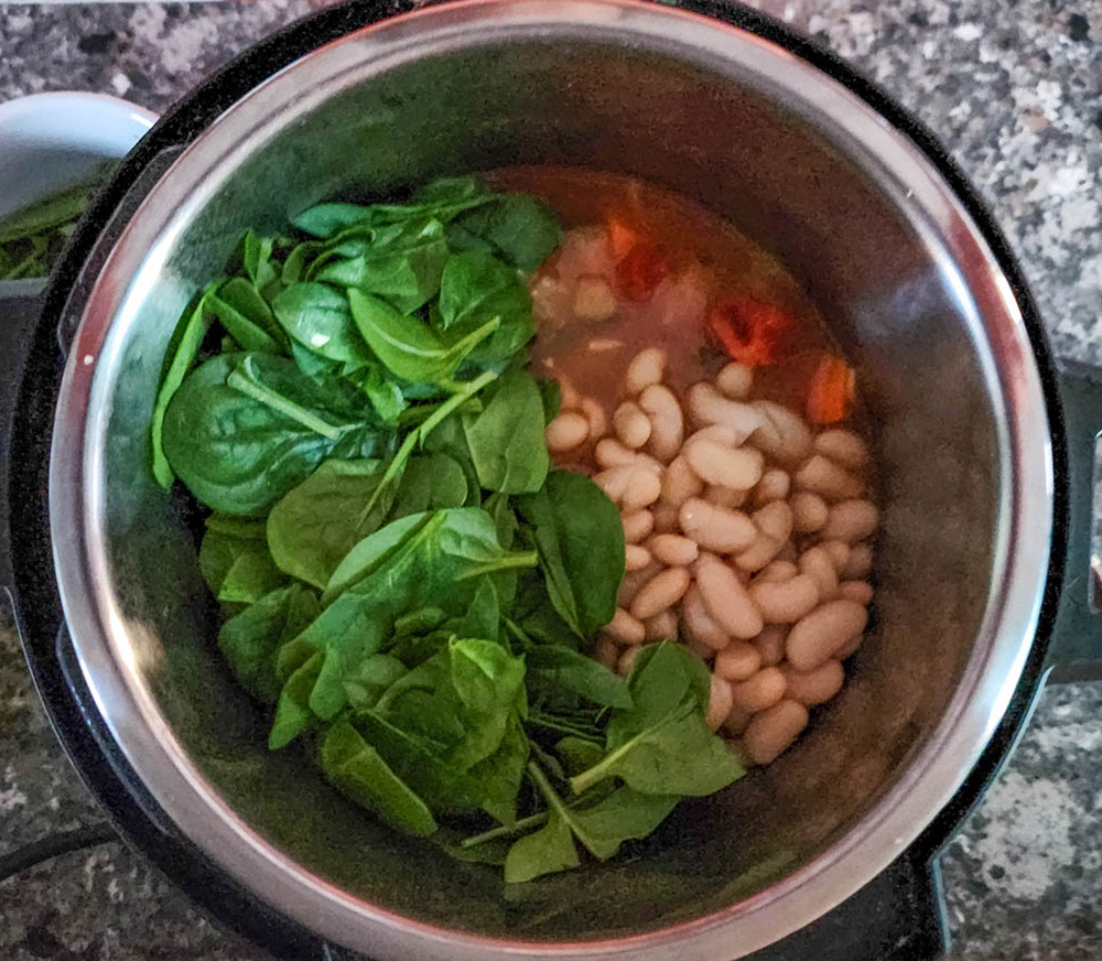 Cooked soup in an instant pot with spinach added