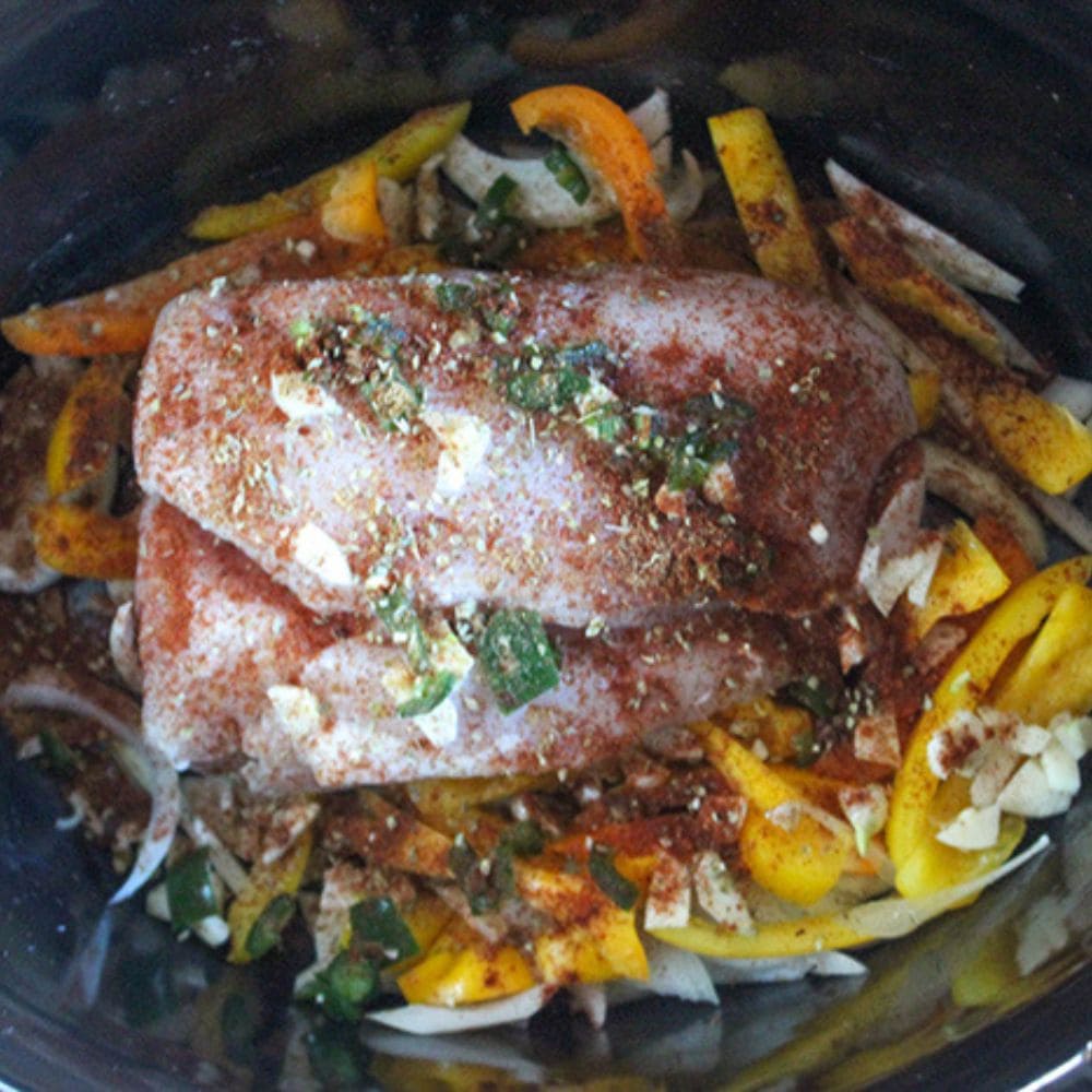 a picture of chicken breasts with spices and jalapeno peppers on top