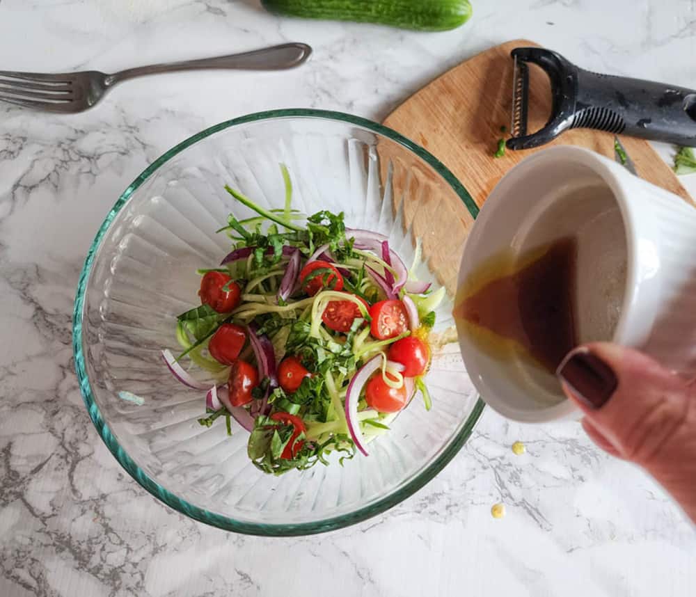 a picture of dressing pouring into salad