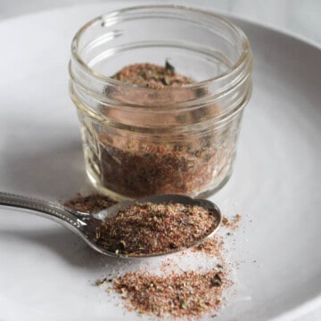 cajun spice blend in a jar with a spoon on the side