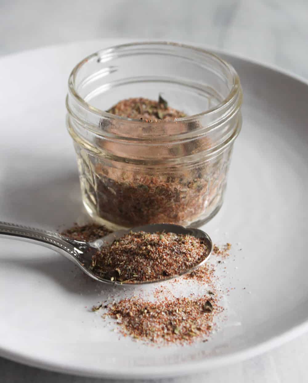 cajun spice blend in a jar with a spoon on the side