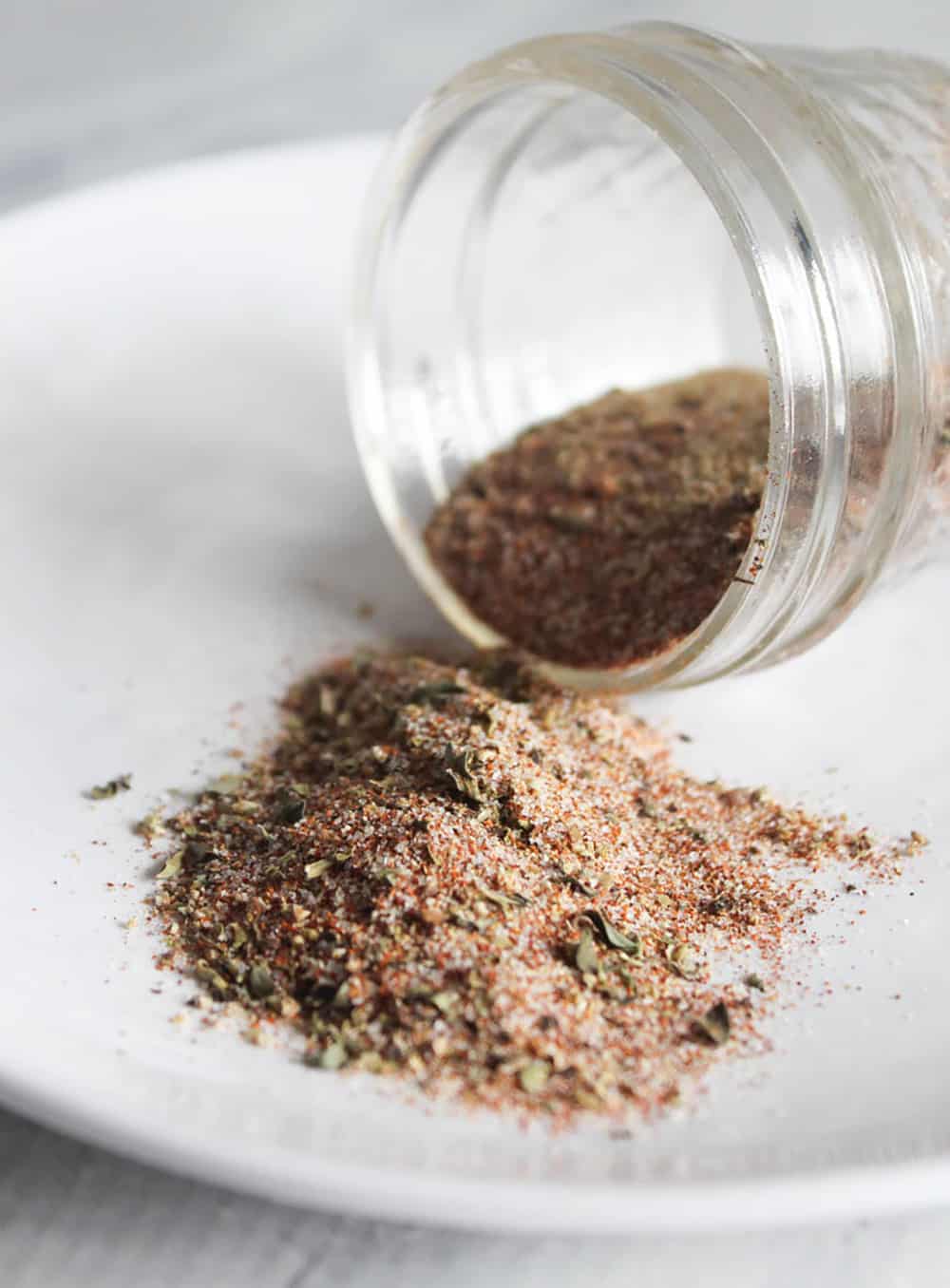 spice blend in a jar spilled on a plate