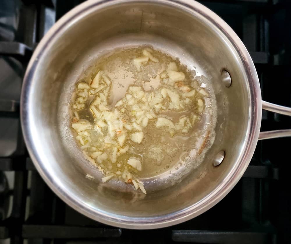 a picture of melted butter with garlic in a saucepan