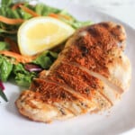 a picture of blackened chicken sliced on a plate with a salad