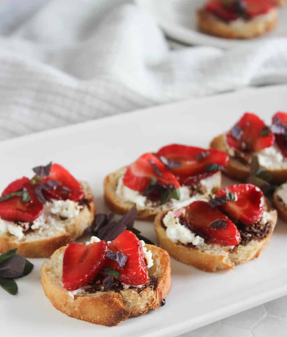 a close up picture of crostini on a white platter