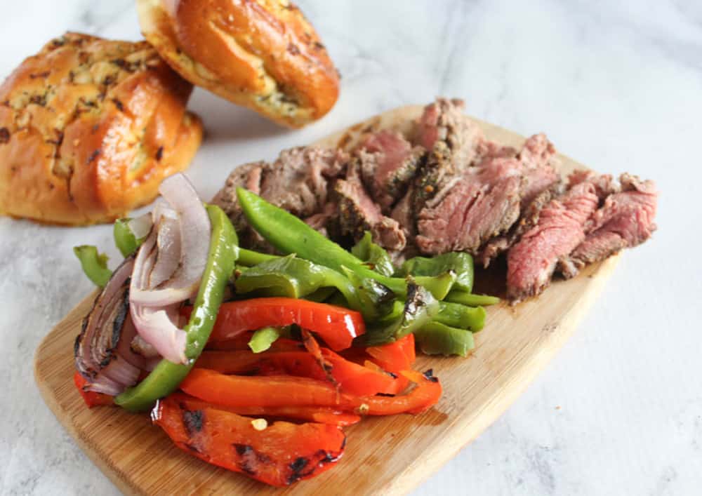 a picture of sliced beef and vegetables on a board