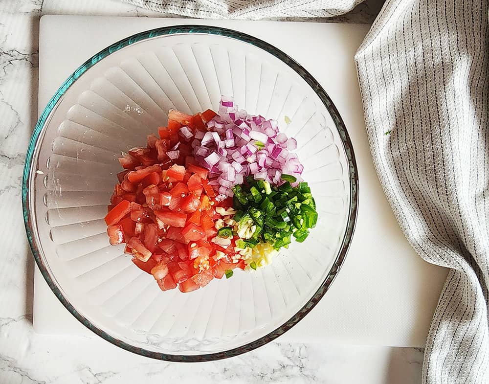 a picture of tomatoes, onions and peppers in a bowl