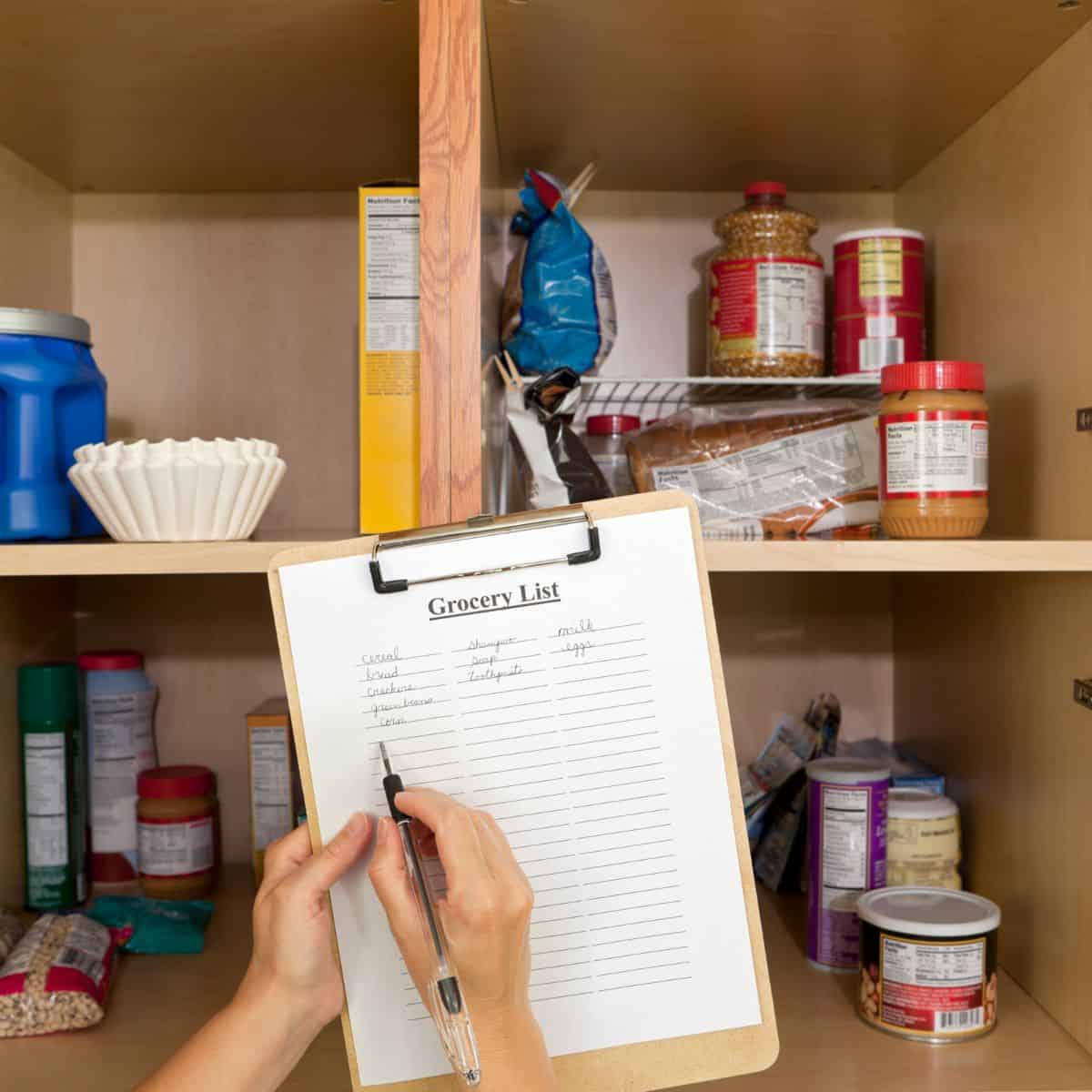 a picture of almost empty pantry with hands writing a shopping list