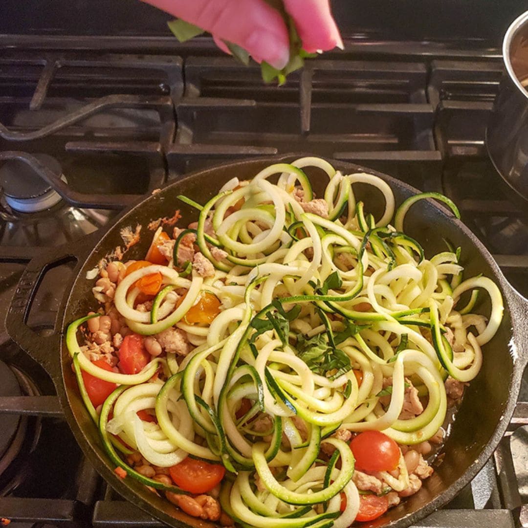 last process step herbs being added to the skilet with zucchini and chicken