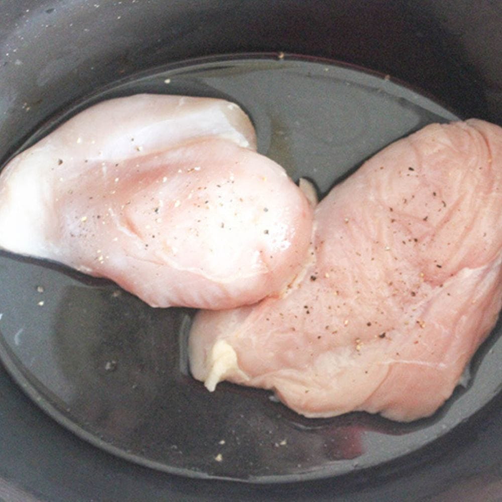 process step 1, raw chicken breasts in a slow cooker