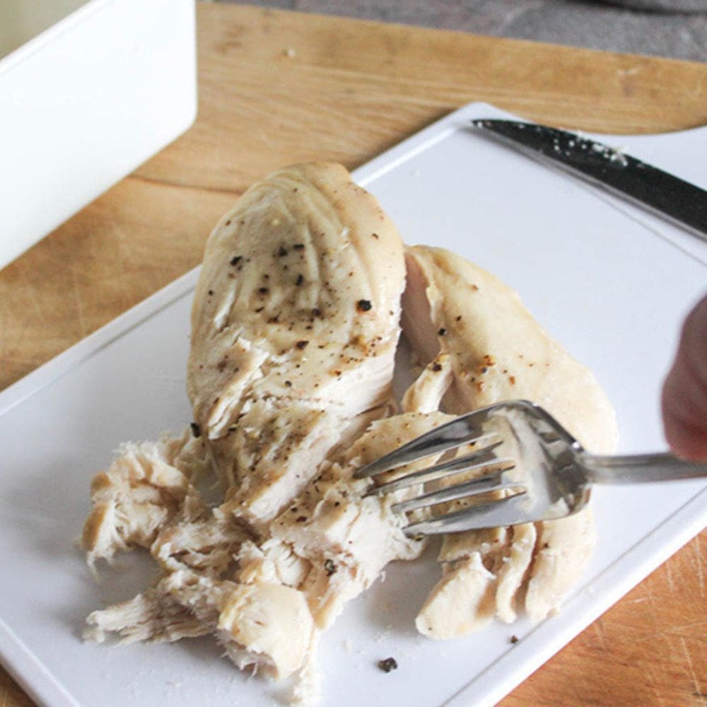 slow cooker shredded chicken step 3, a fork shredding the chese