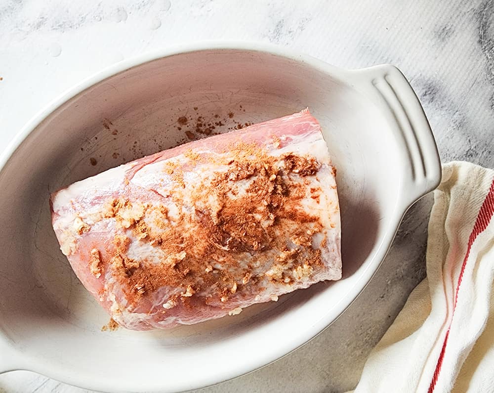a picture of raw pork roast with garlic and cinnamon rub