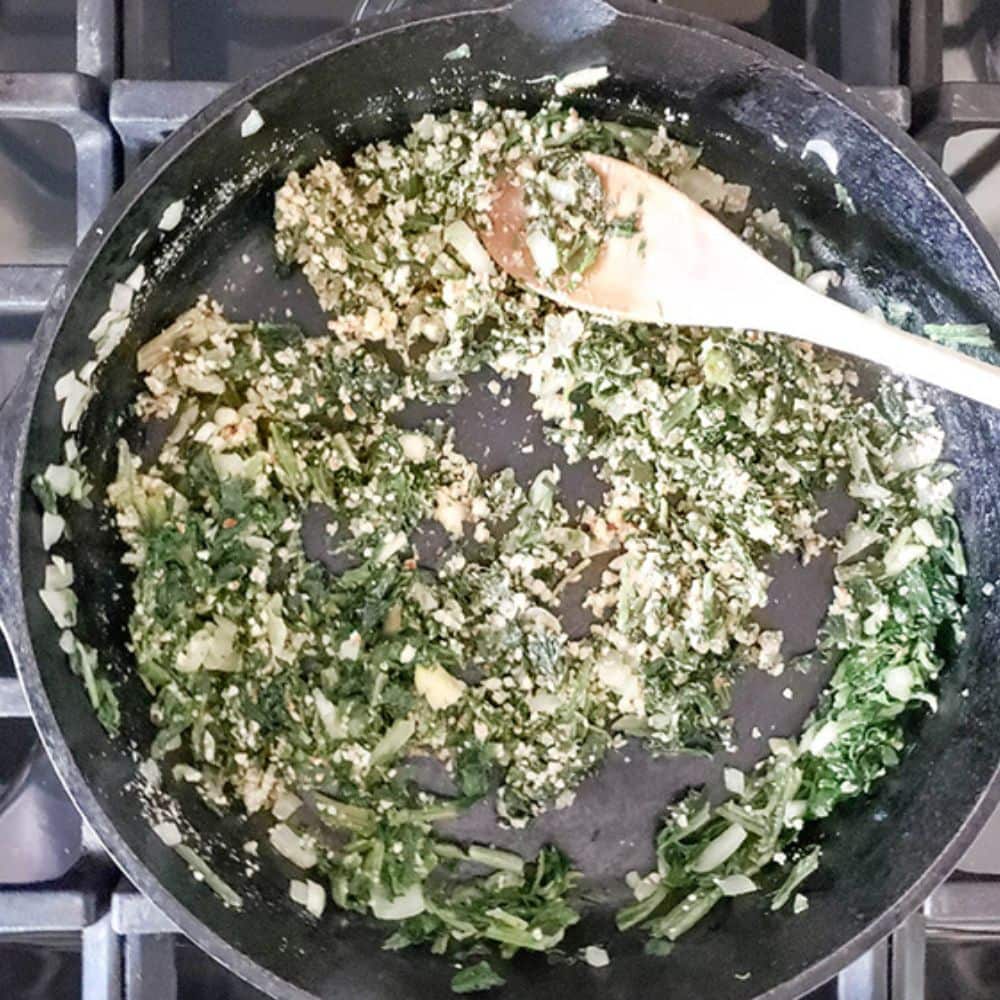 spinach balls process: spinach, onions and almonds cooking in a skillet
